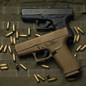 two GLOCK 43 Subcompact 9mm pistol brown and black side profile resting on a neutral background buy GLOCK 43 Subcompact 9mm pistol online