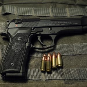 Beretta 92 FS 9mm Centerfire Pistol side profile on a neutral background with 9mm bullets on the side
