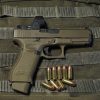glock 19 semi auto image on a green bg with some 9mm luger ammunition